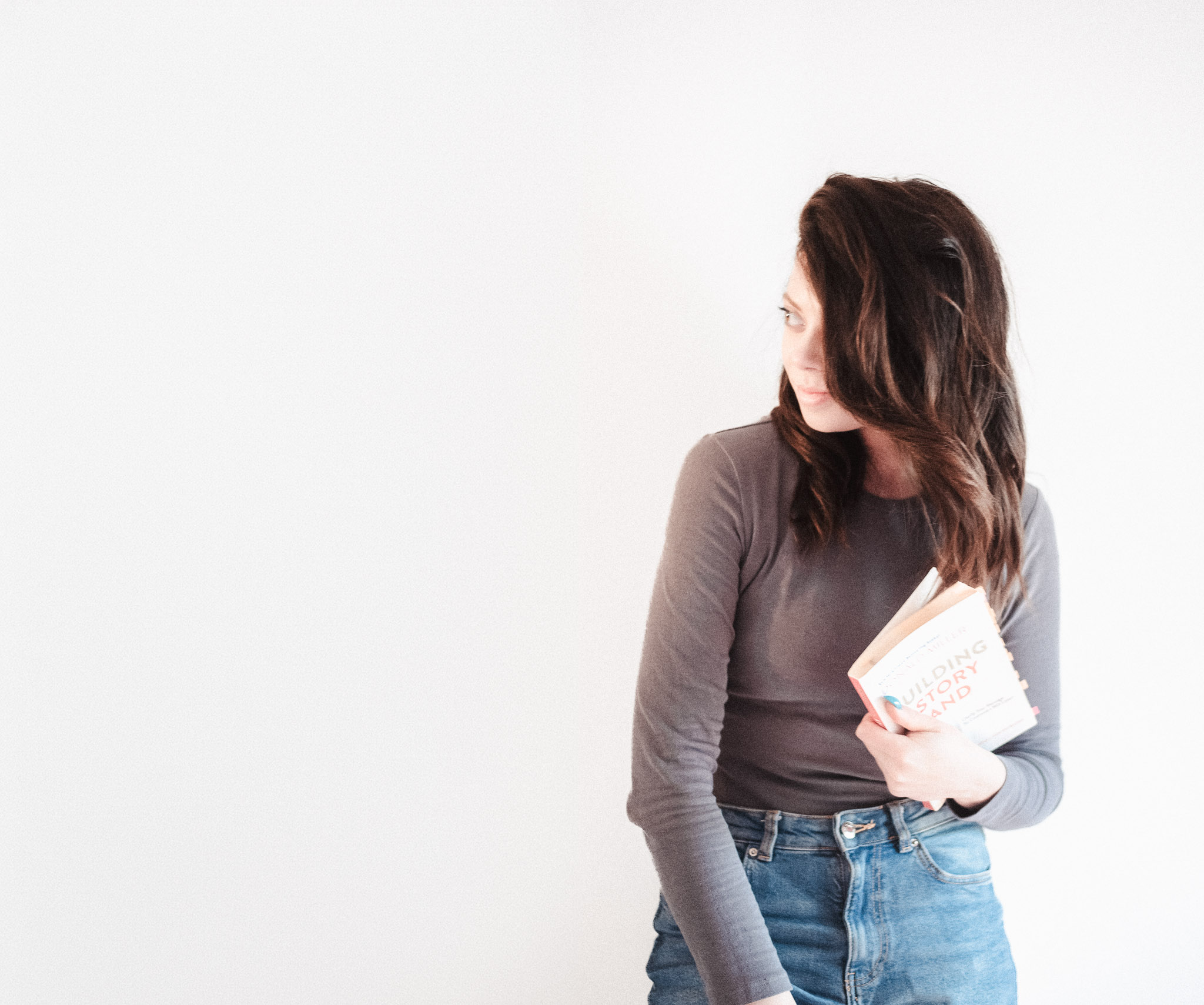 Keshia from The Copy Therapist poses against a white background with the StoryBrand book